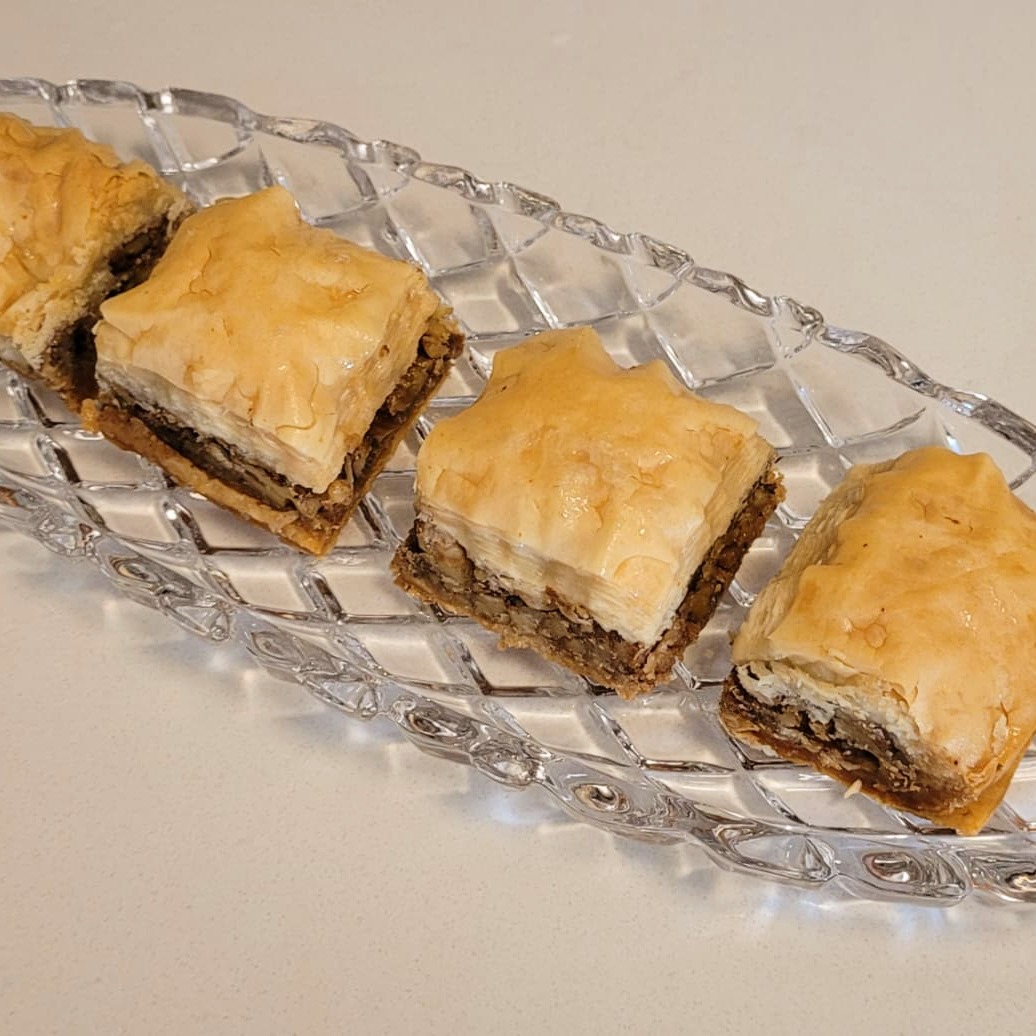 Baklava squares — golden layered phyllo pastry with walnut filling, glistening with syrup