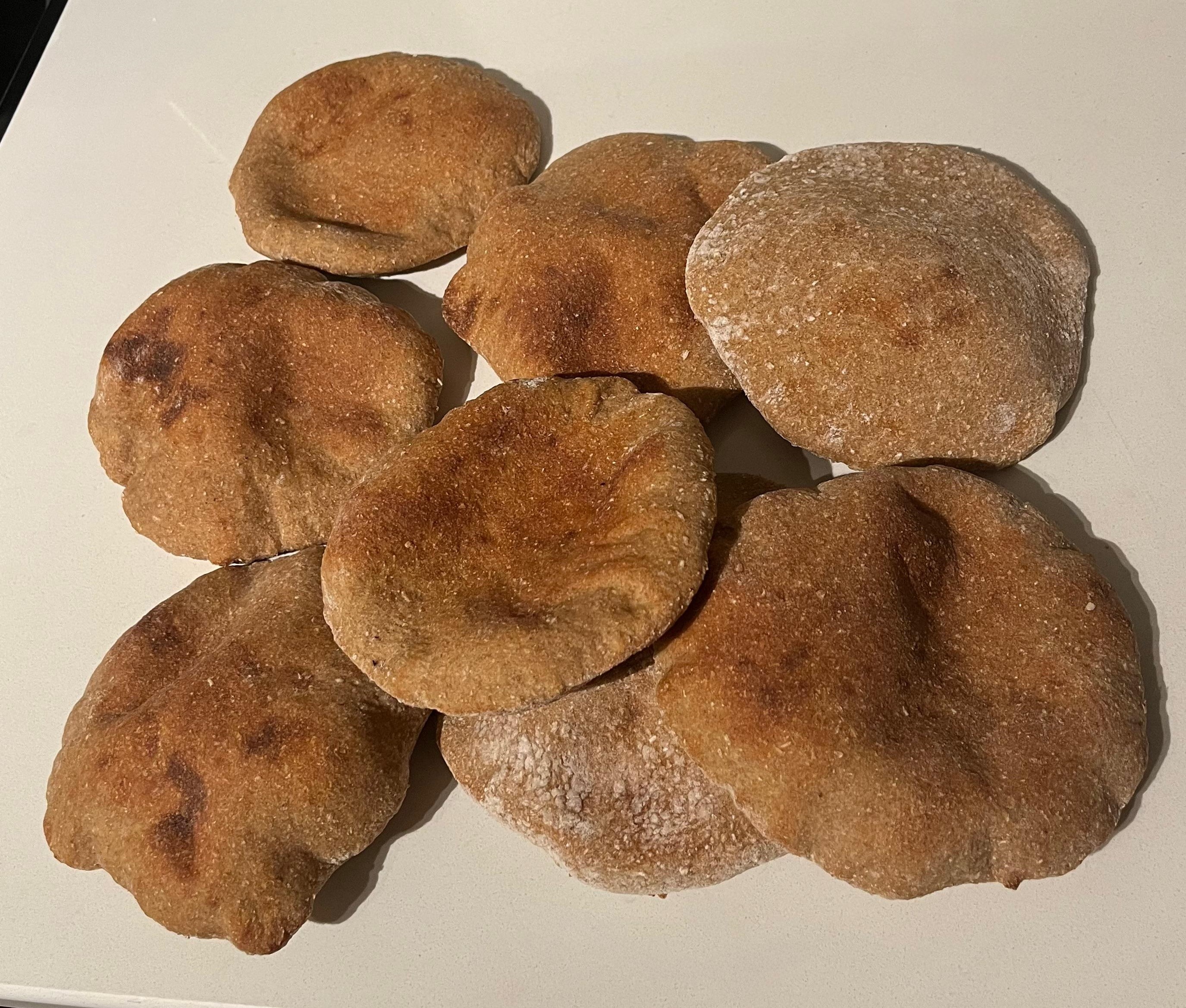 Homemade flatbreads — golden-brown rustic pita-style rounds piled together